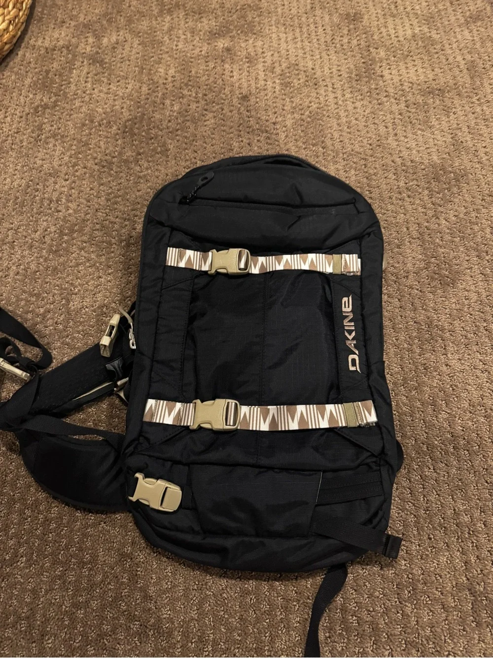 Dakine Black hydration Backpack with Tan Patterned Straps and hip straps